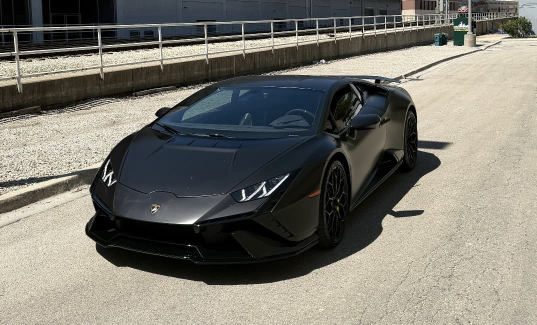 2023 Lamborghini Huracán Tecnica in black — front three-quarter view with its fixed rear wing, for sale from DDE Rentals