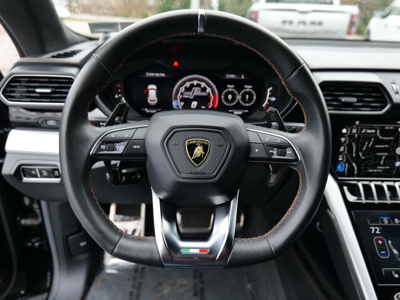 Driver's cockpit of the 2021 Urus — contrast-stitched steering wheel, digital cluster and dual touchscreens