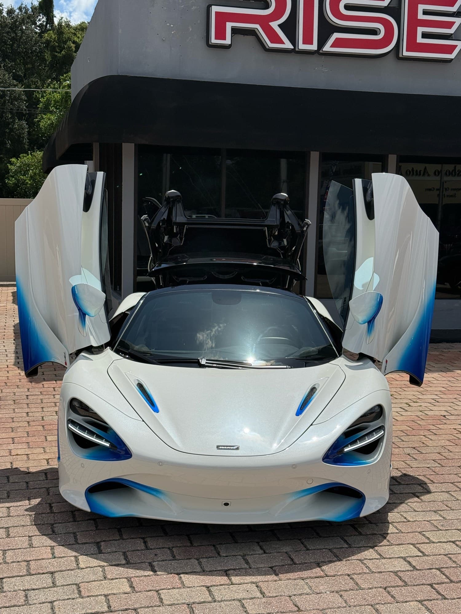 Head-on view of the 720S Spider with both dihedral doors raised and the retractable hardtop open
