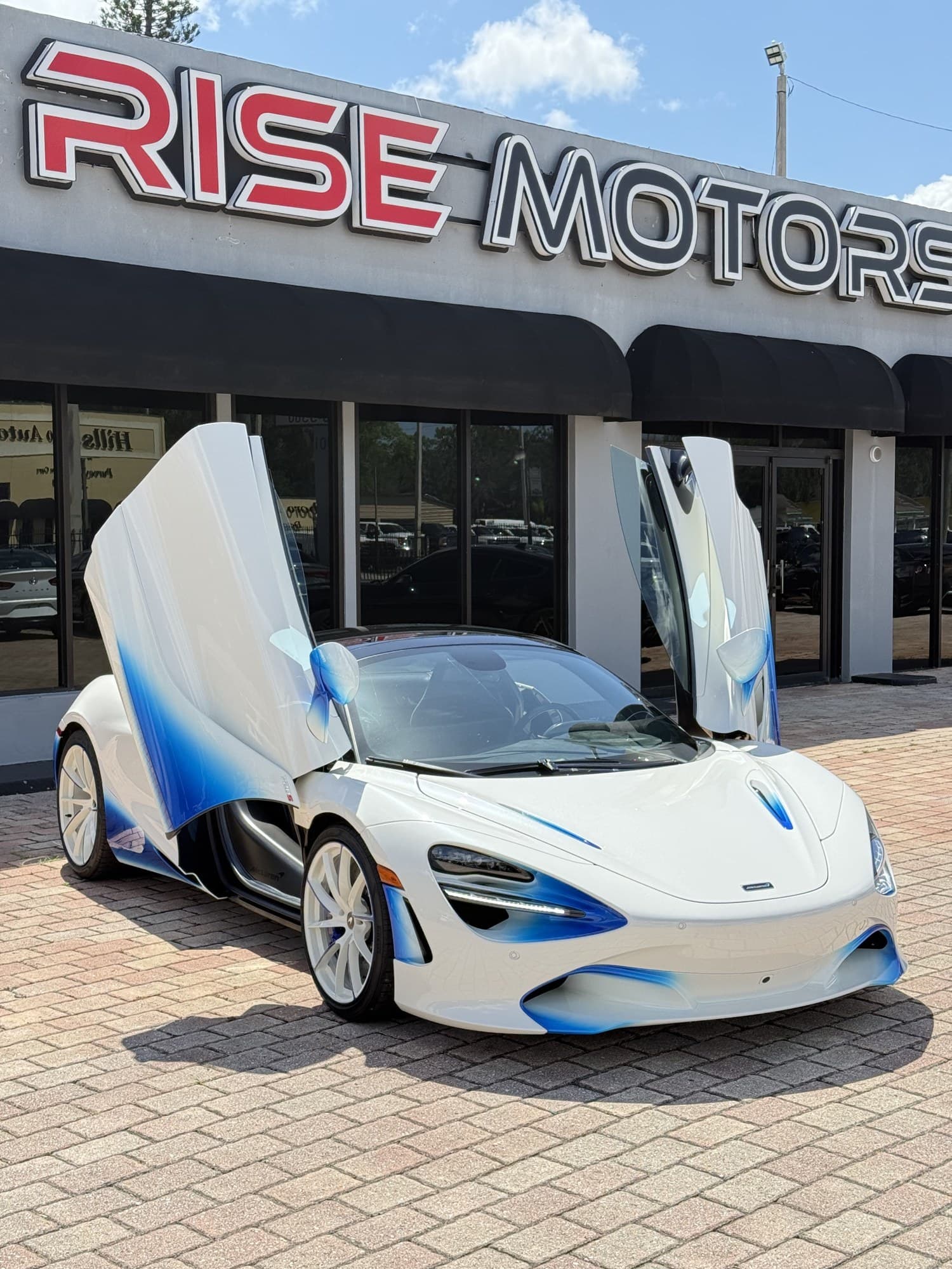 Wide front three-quarter view of the 720S Spider, dihedral doors raised