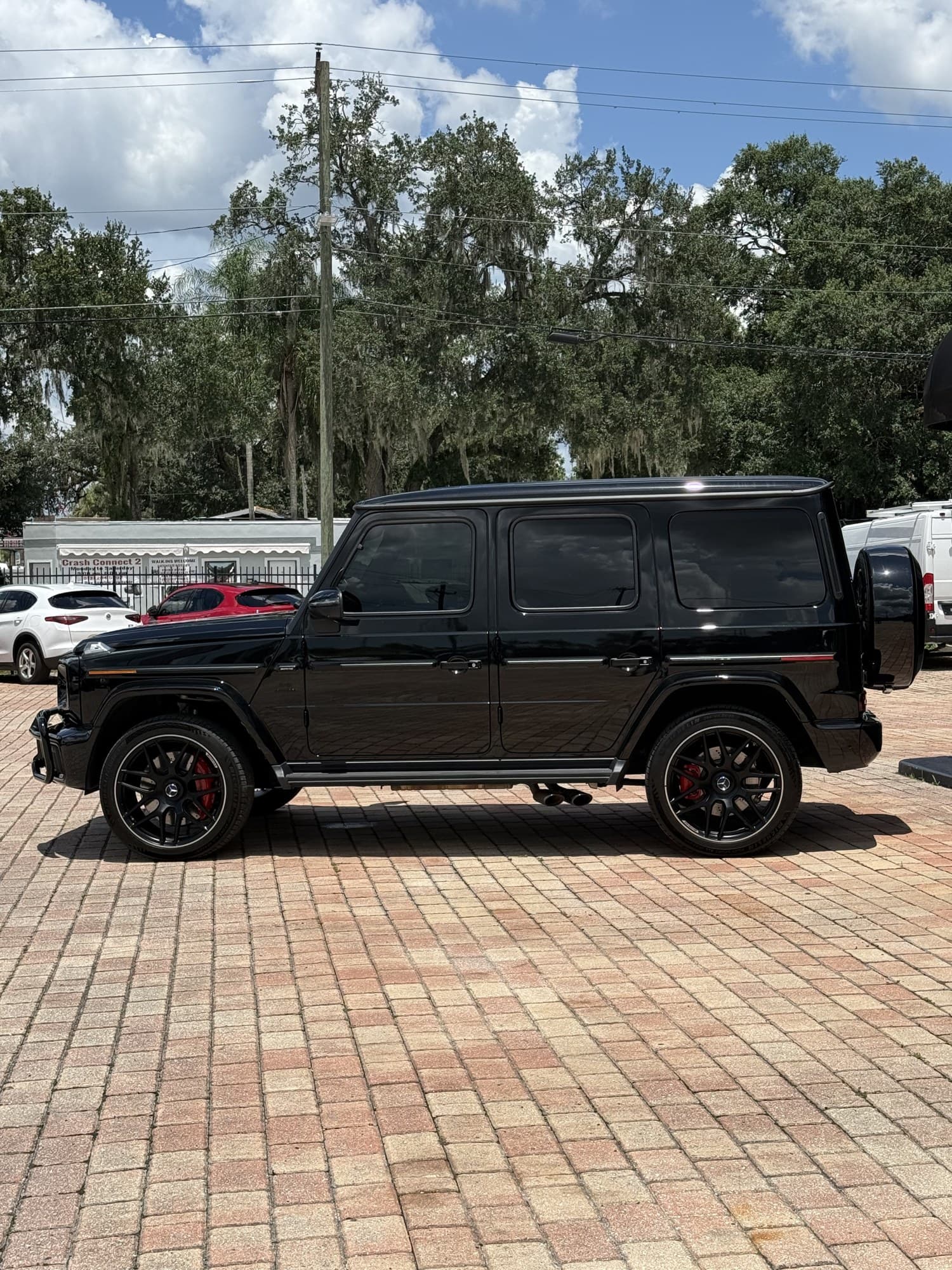 Driver-side profile of the 2025 G 63 on 22-inch AMG forged wheels with red calipers