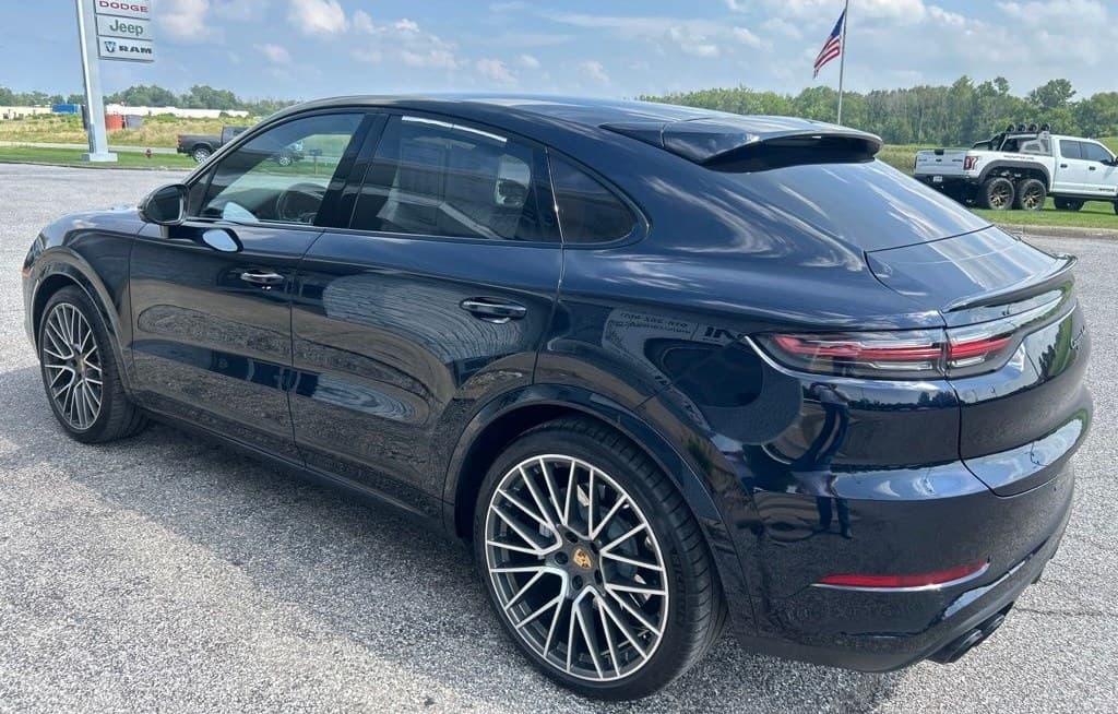 Rear three-quarter view showing the Cayenne Coupe's sloping roofline and adaptive spoiler
