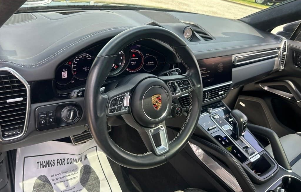Driver's cockpit of the Cayenne Turbo Coupe — sport steering wheel, analog tach and centre console