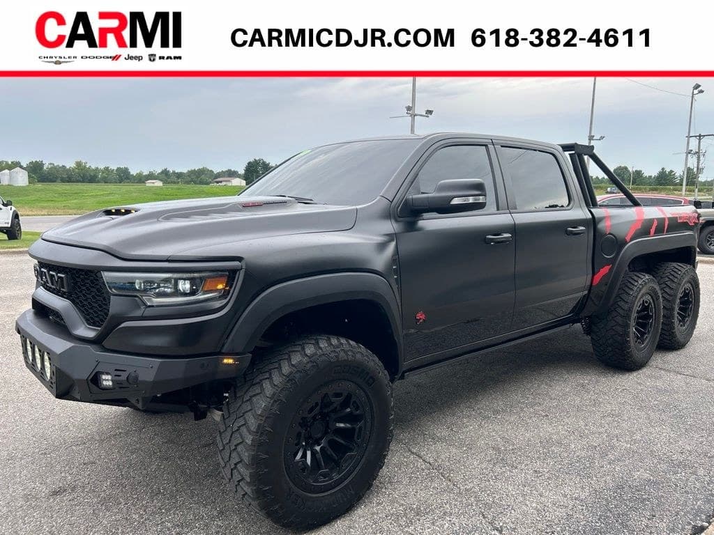 Side view of the matte-black TRX 6x6 on six black wheels with mud-terrain tires